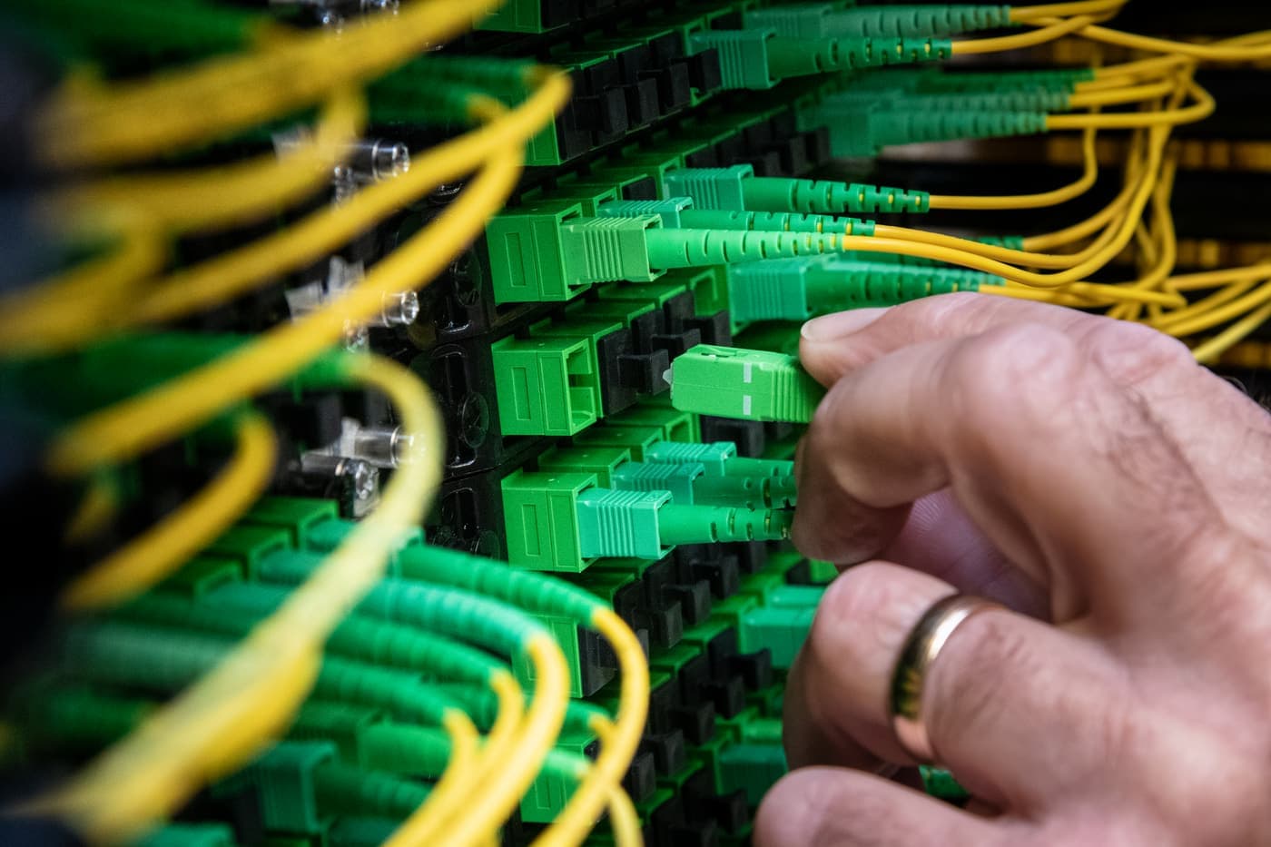 Technician connecting fibre patch cables in a rack